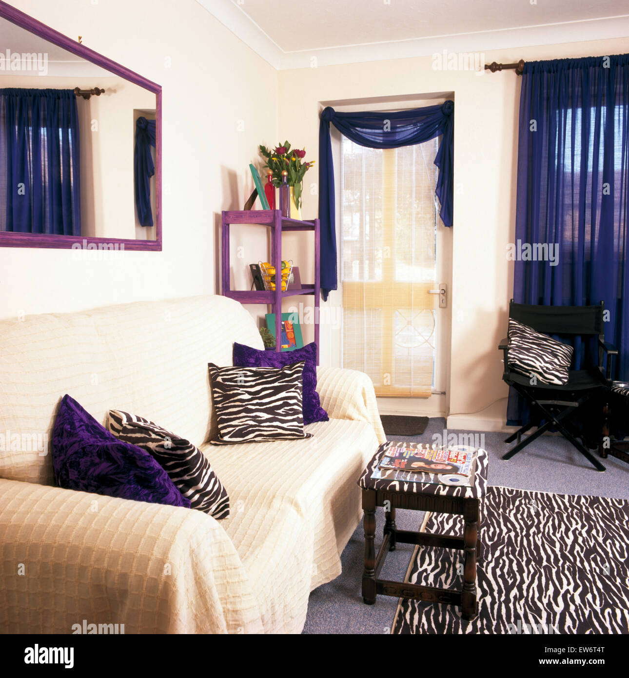 Cream throw on sofa in economy living room Stock Photo Alamy