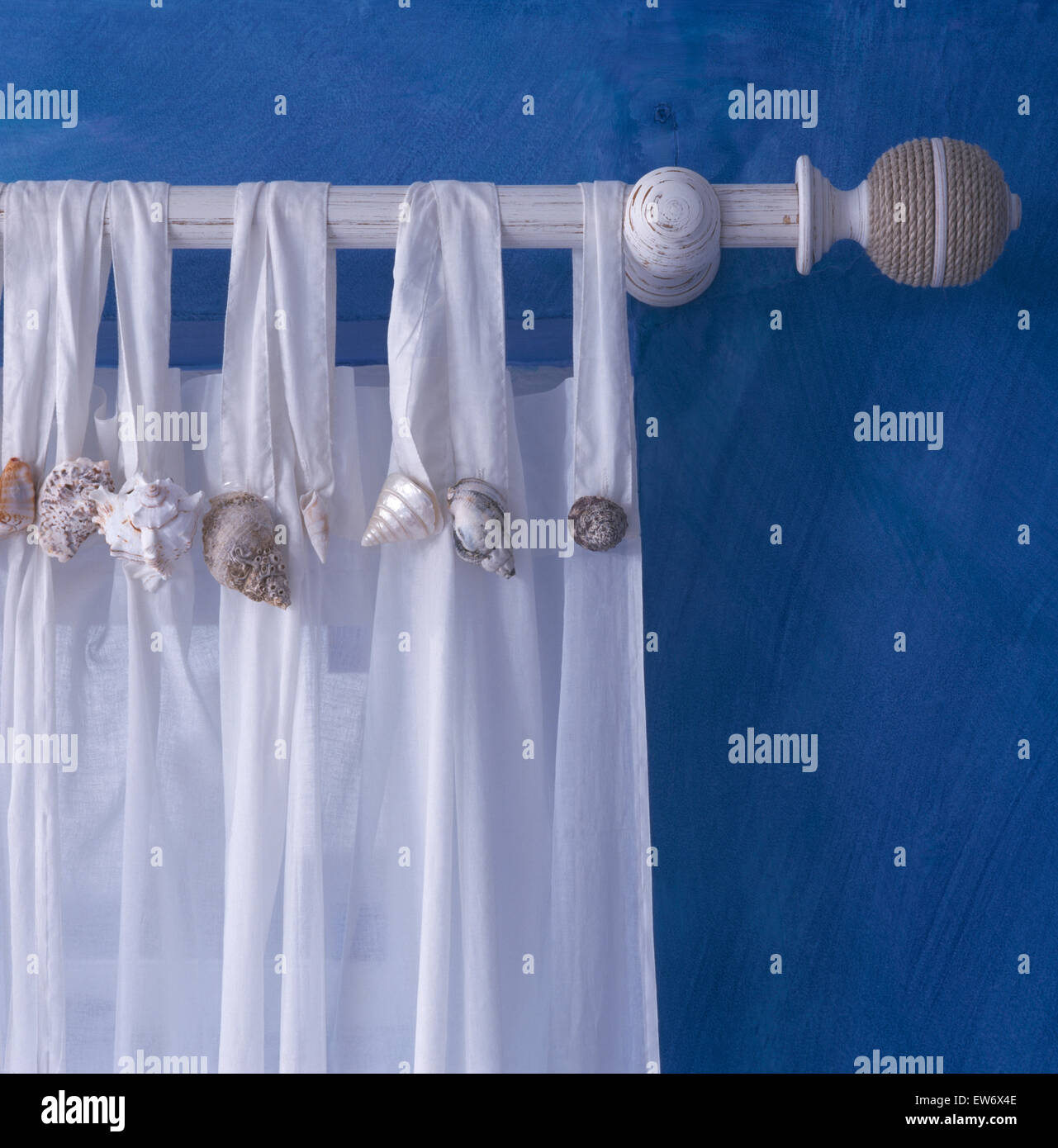 Close Up Of White Cotton Curtain Trimmed With Seashells On A White