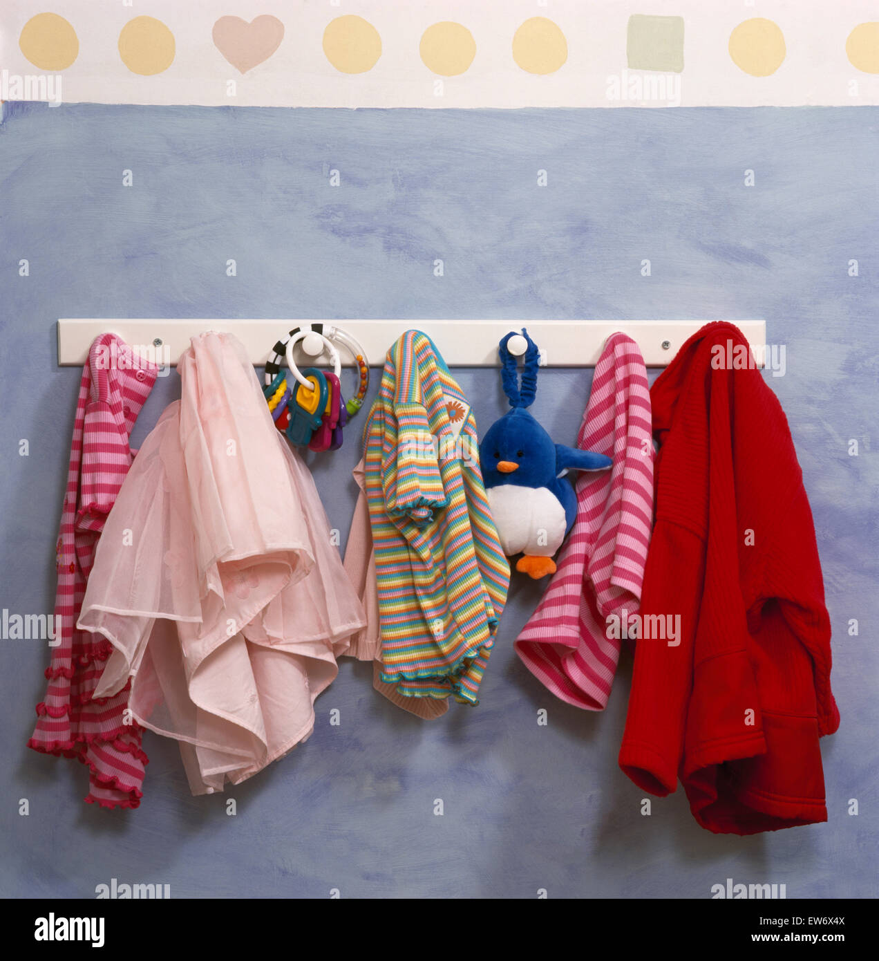 Close-up of children's clothes on a small peg rail Stock Photo