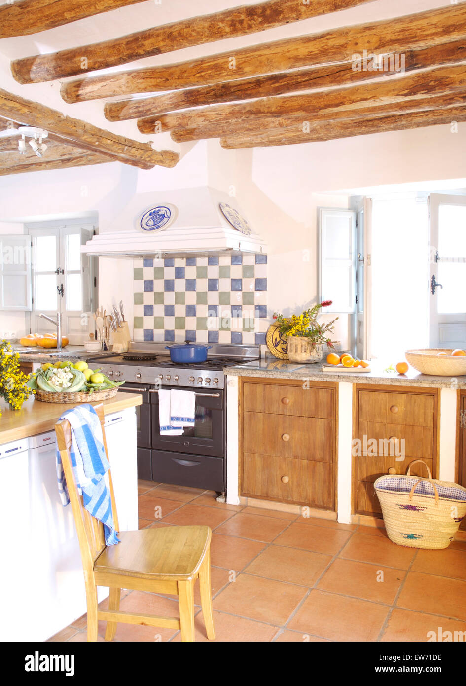 Blue+white tiled splash back above range oven in Spanish country kitchen with terracotta tiled