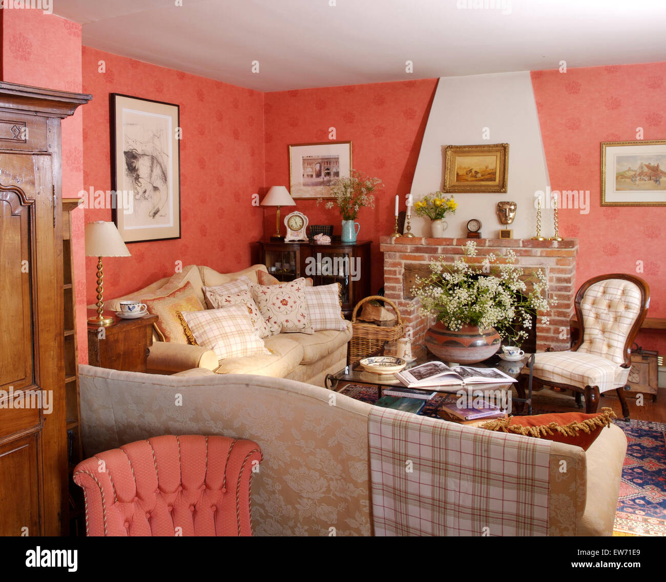 Checked throw on the back of damask sofa in deep pink country living room Stock Photo Alamy