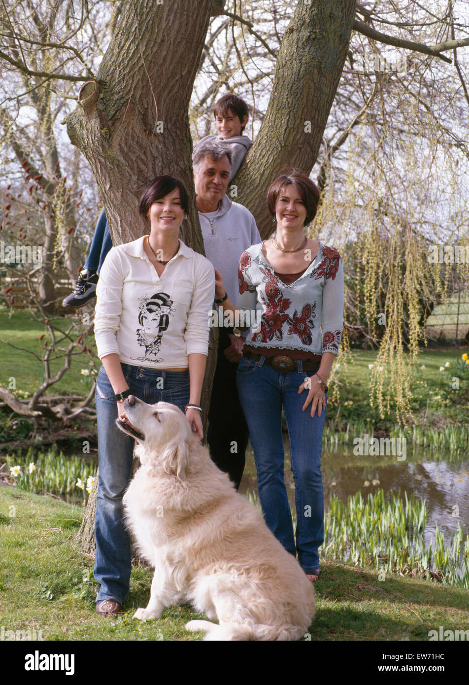 Portrait of family with golden retriever dog standing in country garden          FOR EDITORIAL USE ONLY Stock Photo