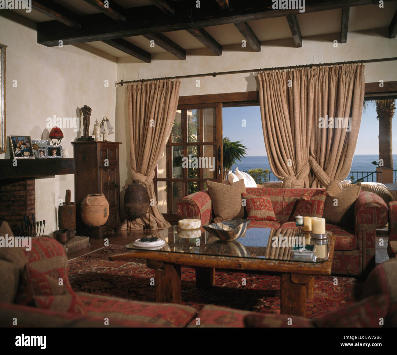 Living Room In Spanish Villa With Heavy Beige Drapes On Patio