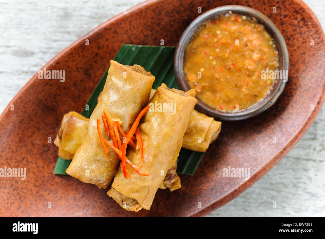 Indonesian-style spring rolls served with sambal dipping sauce and red chillies. Stock Photo