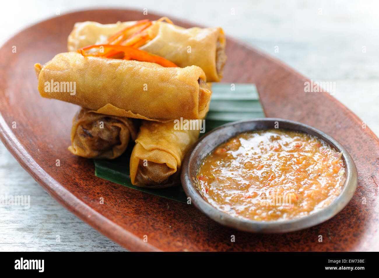 Indonesian-style spring rolls served with sambal dipping sauce and red chillies. Stock Photo