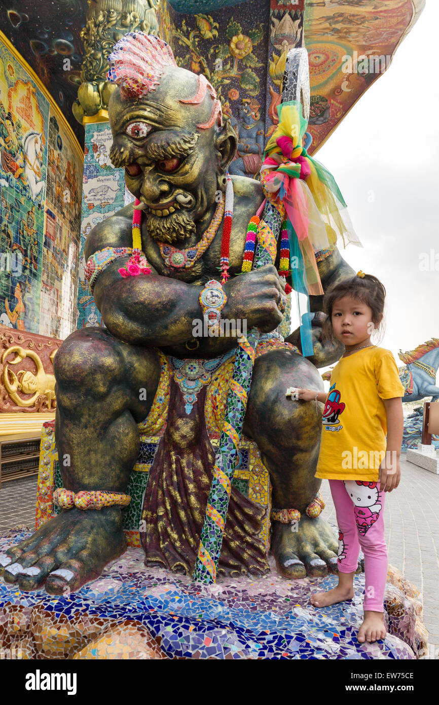 Girl rubbing banknote at a Yaksa statue, yak, Elephant Temple Thep Wittayakhom Vihara, Wittayakom, Wat Baan Rai, Korat Stock Photo