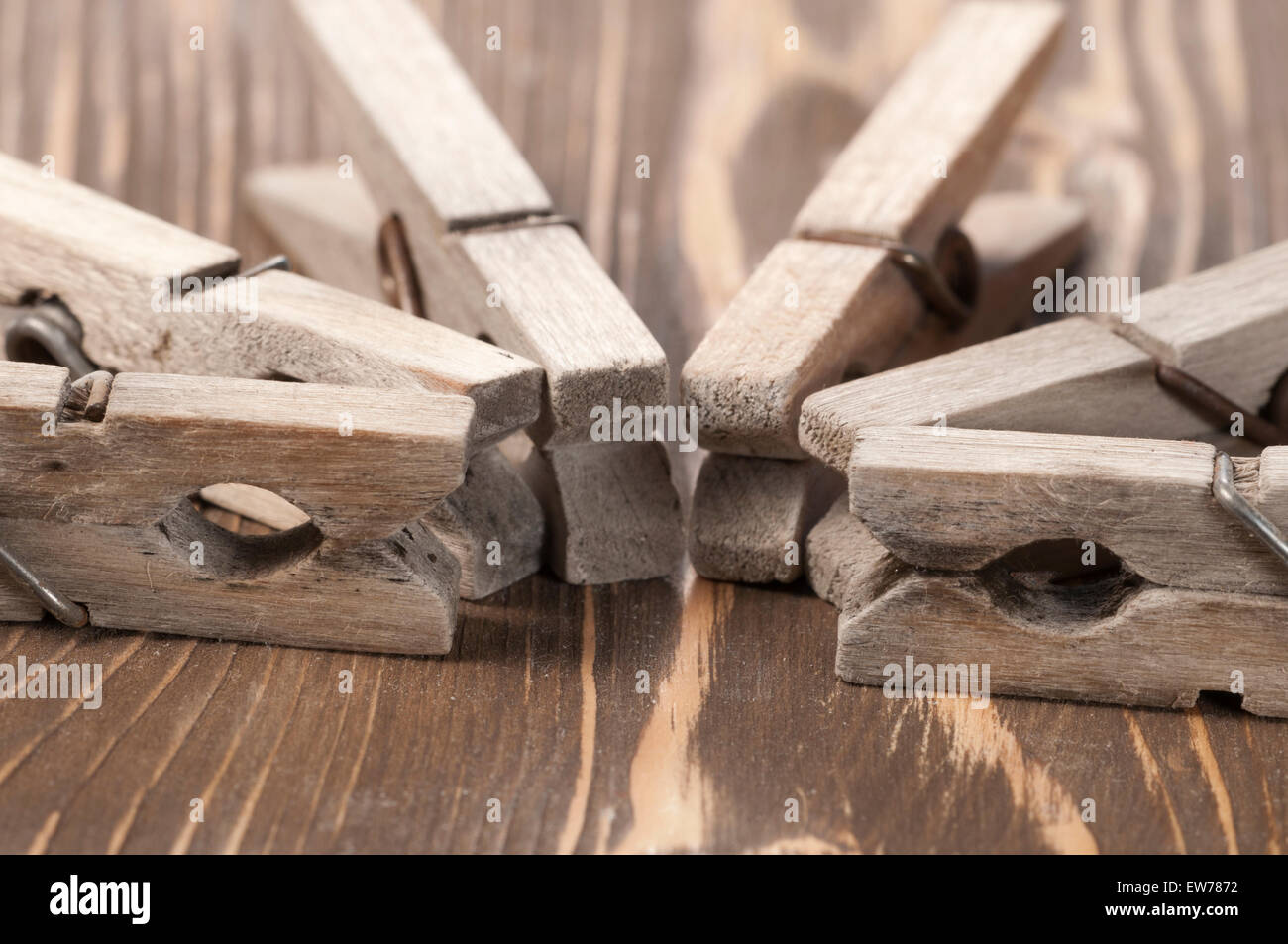 Old wooden clothes pins  on a timber board, close-up Stock Photo