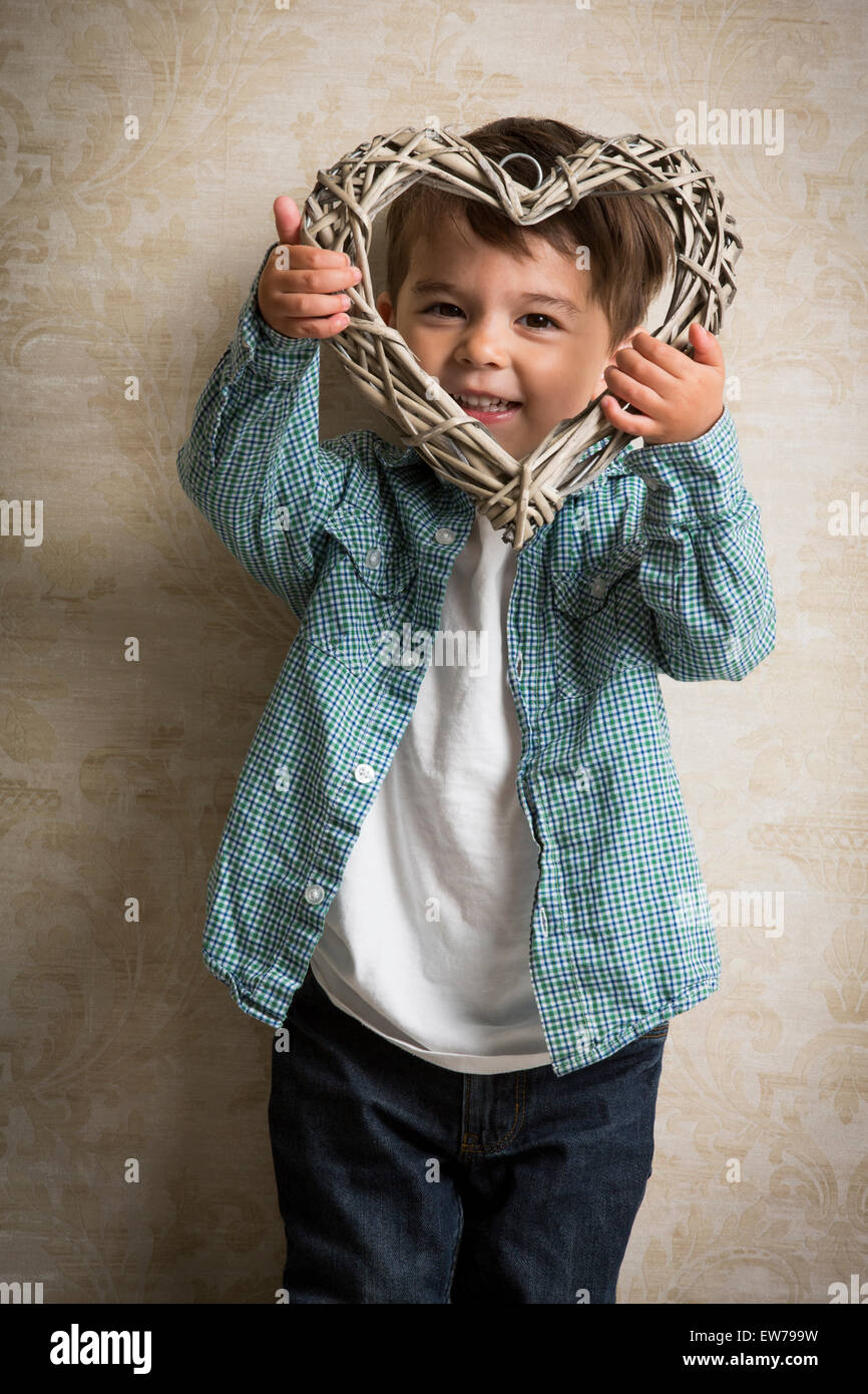 Little boy holding a wooden heart in his hand Stock Photo