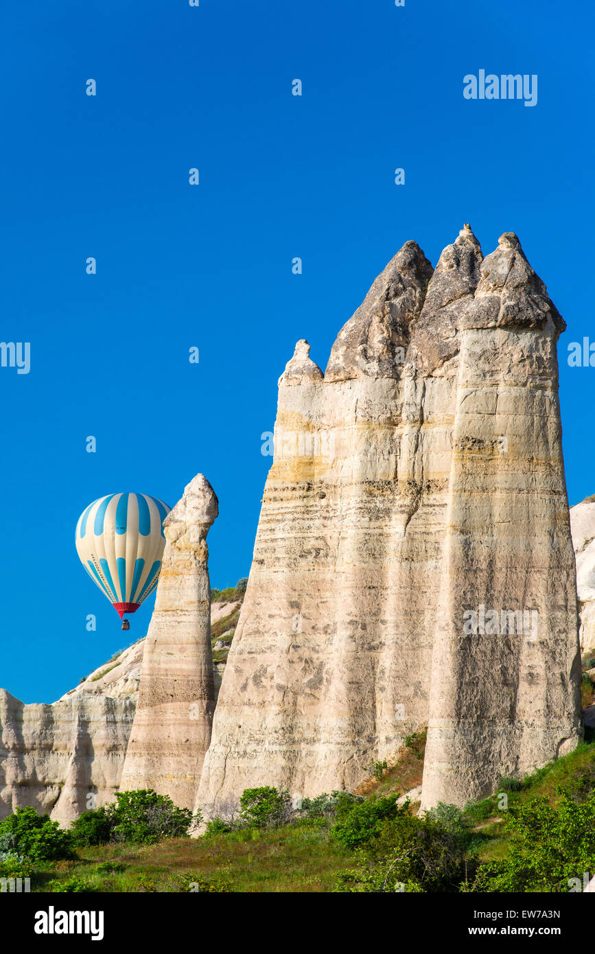 Scenic fairy chimneys landscape with hot air balloon, Goreme, Cappadocia, Turkey Stock Photo