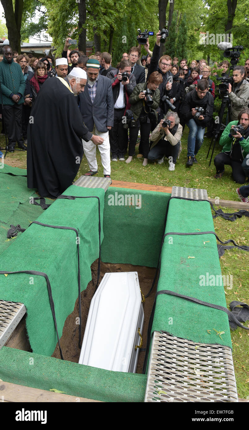 Berlin, Germany. 19th June, 2015. The coffin with the mortal remains of a 60-year old refugee is lowered into the grave on the cementary Alter Zwoelf-Apostel-Kirchhof in Berlin, Germany, 19 June 2015. The funeral is an initiative of the 'Zentrum für Politische Schoenheit' (lit. Centre for political beauty) that protests against the EU refugee policies with this campaign. It is the second funeral of its kind. Photo: RAINER JENSEN/dpa/Alamy Live News Stock Photo