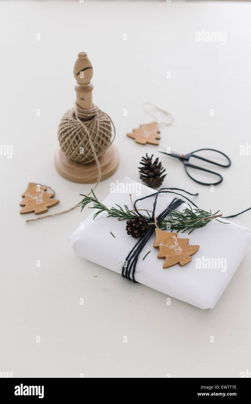 Still life of wrapped christmas present, string, scissors and tags ...