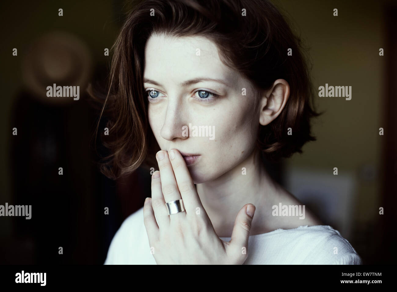 Portrait of a woman holding her hand to her mouth Stock Photo