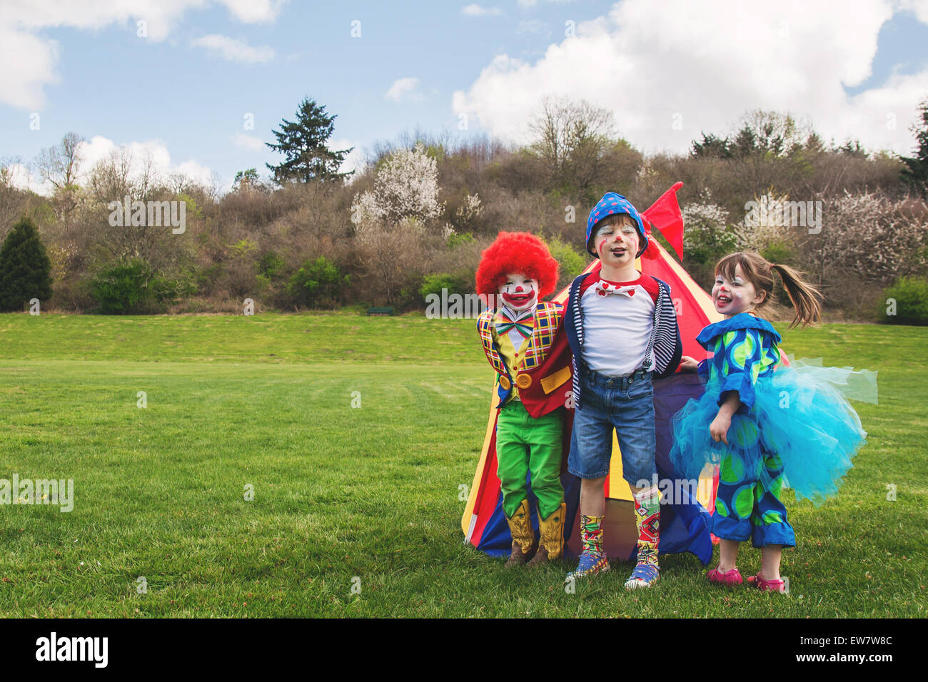 Three smiling children dressed as clowns Stock Photo
