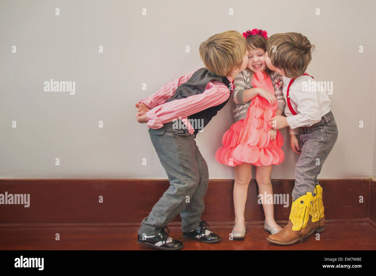 Two boys kissing a girl on the cheek Stock Photo