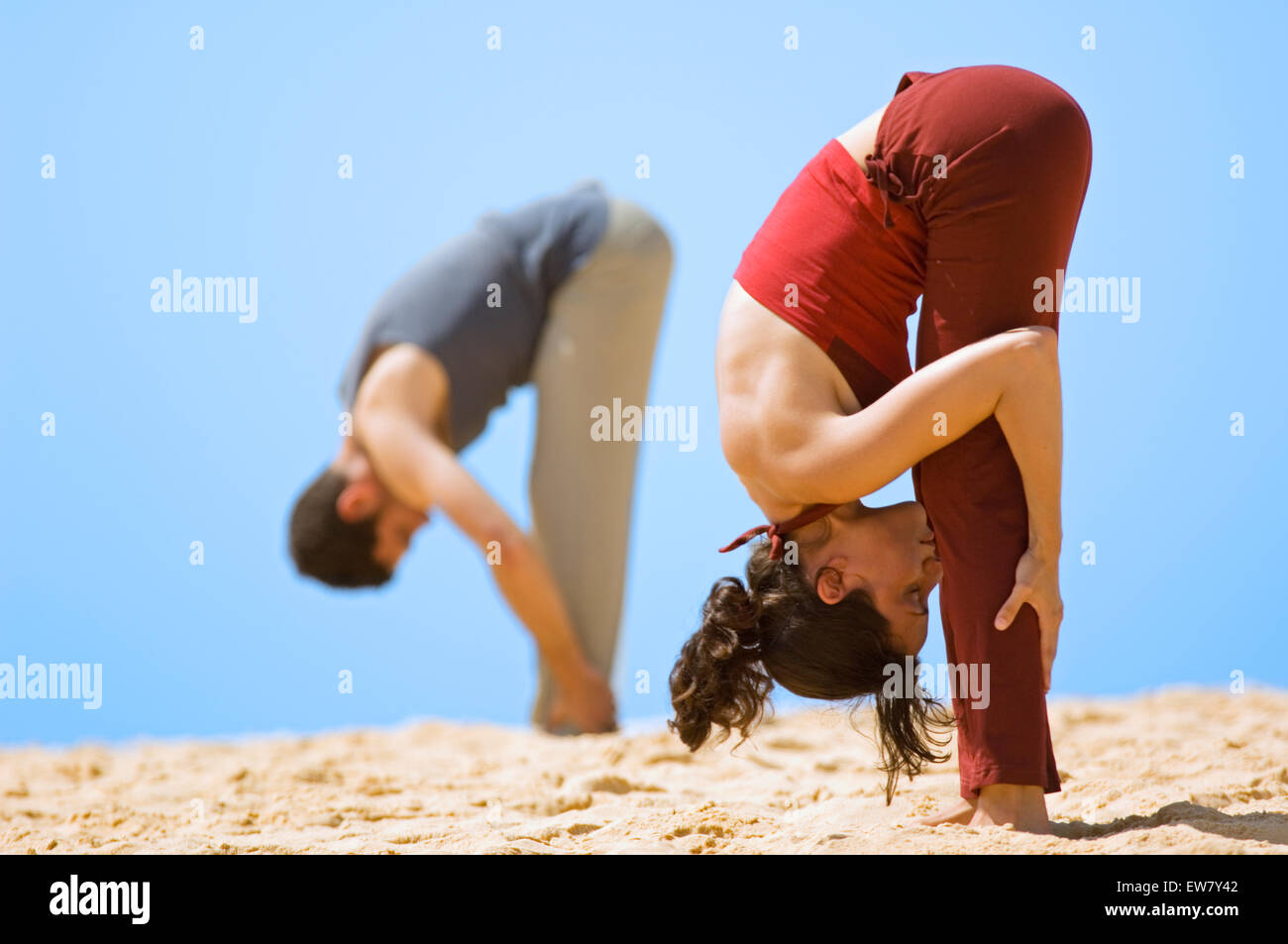 Leyla Brooks and James Fellows practicing yoga on a rocky outcrop at North Curl Curl, one of Sydneys Northern Beaches. Sydney, N Stock Photo