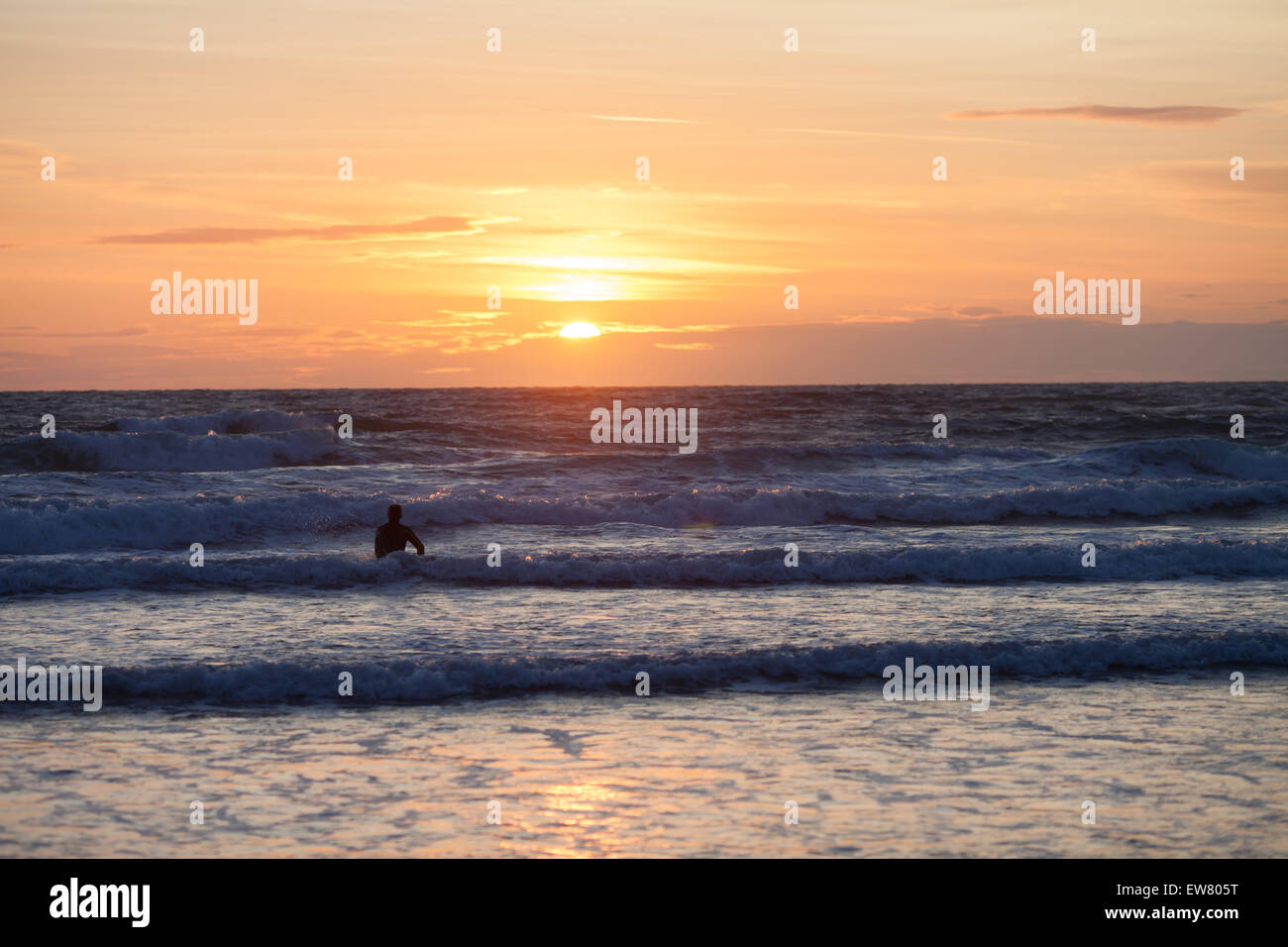 Surfer on the ocean beach at sunset Stock Photo - Alamy