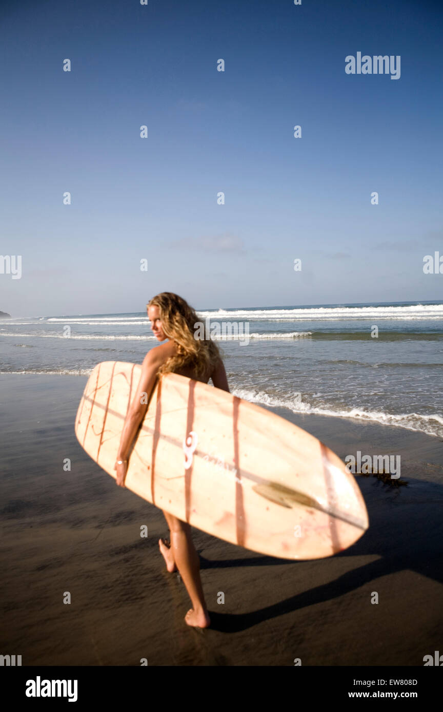 cute young brunette girl enjoys a day at the beach with surf board Stock Photo