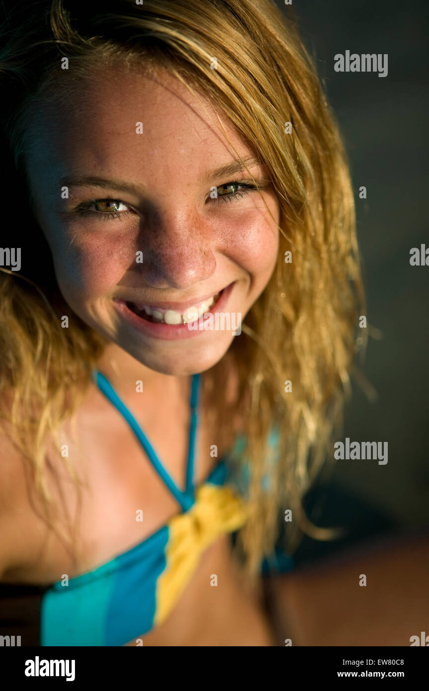 cute teenage blond girl enjoys a day at the beach with surf board Stock Photo