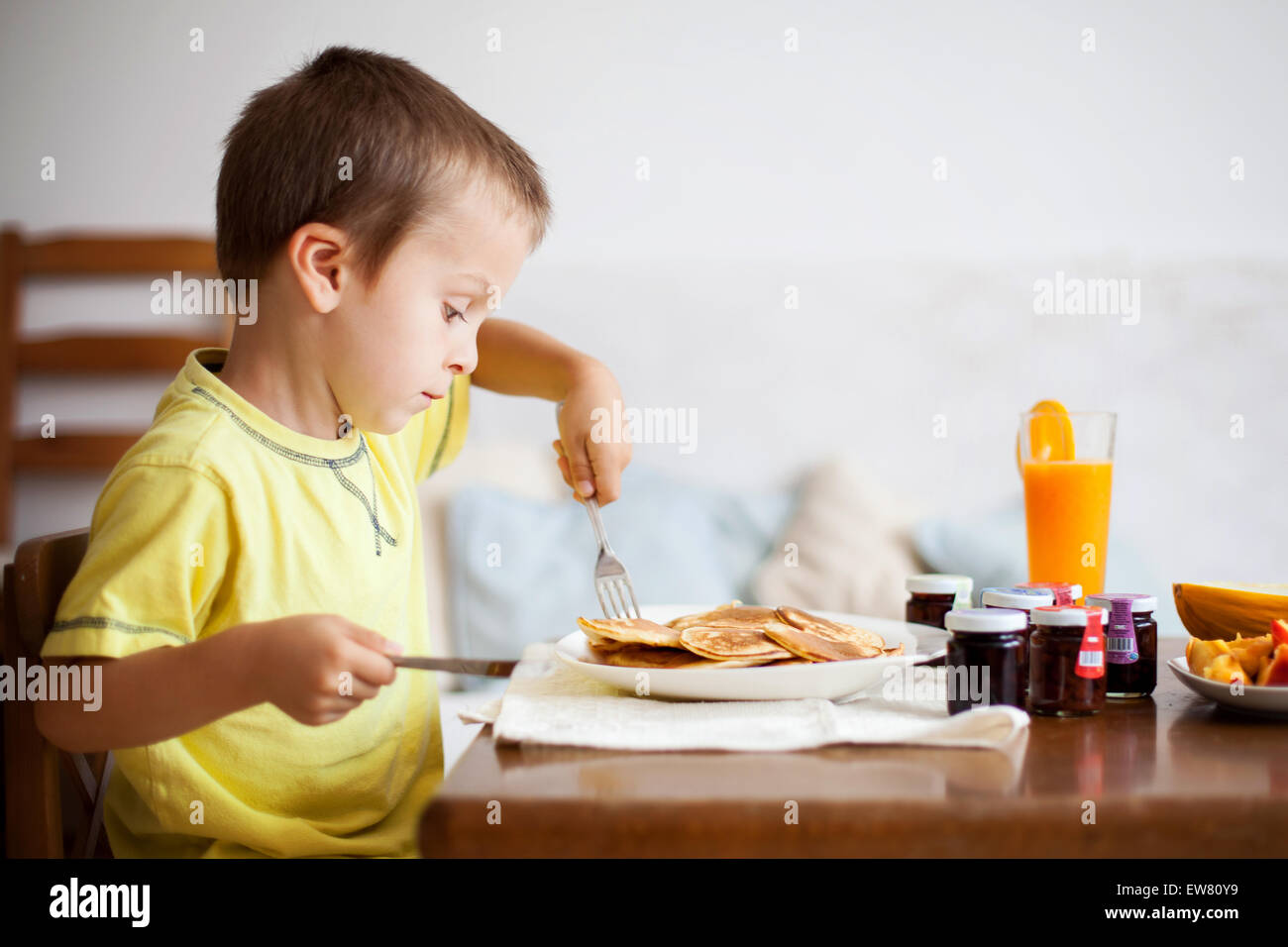 Cute boy, eating pancakes at home Stock Photo Alamy