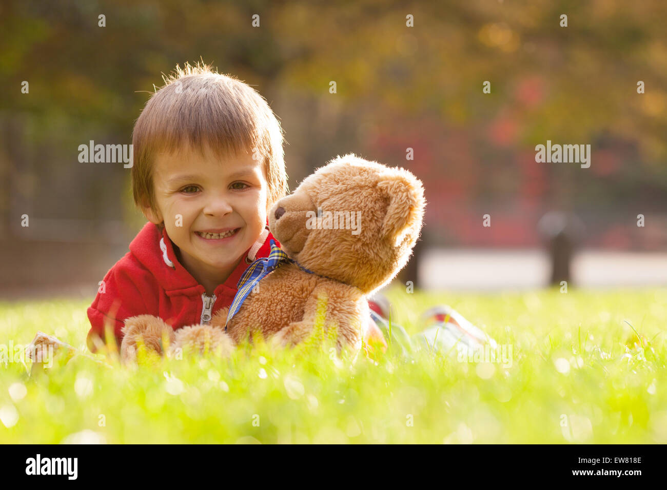 Adorable little boy with teddy bear in the park on an autumn day in the ...