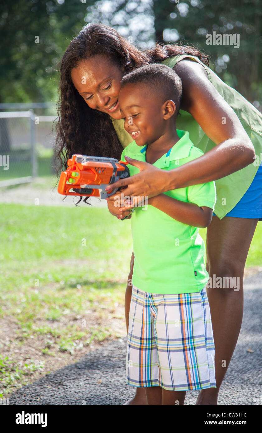 Young African American boy age 4 playing in park with mother and nerf gun  in Florida Stock Photo - Alamy
