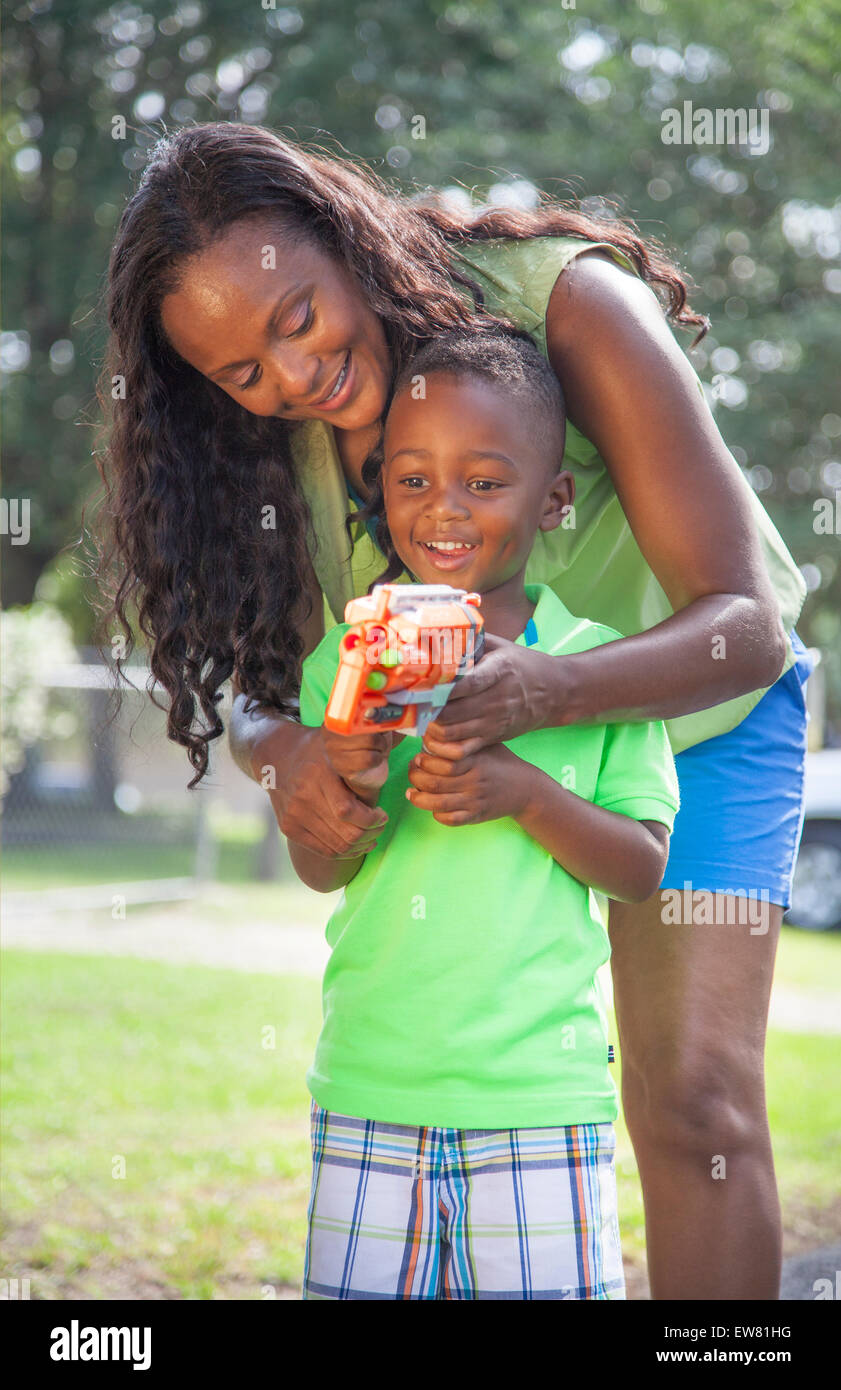 Young African American boy age 4 playing in park with mother and nerf gun in Florida Stock Photo