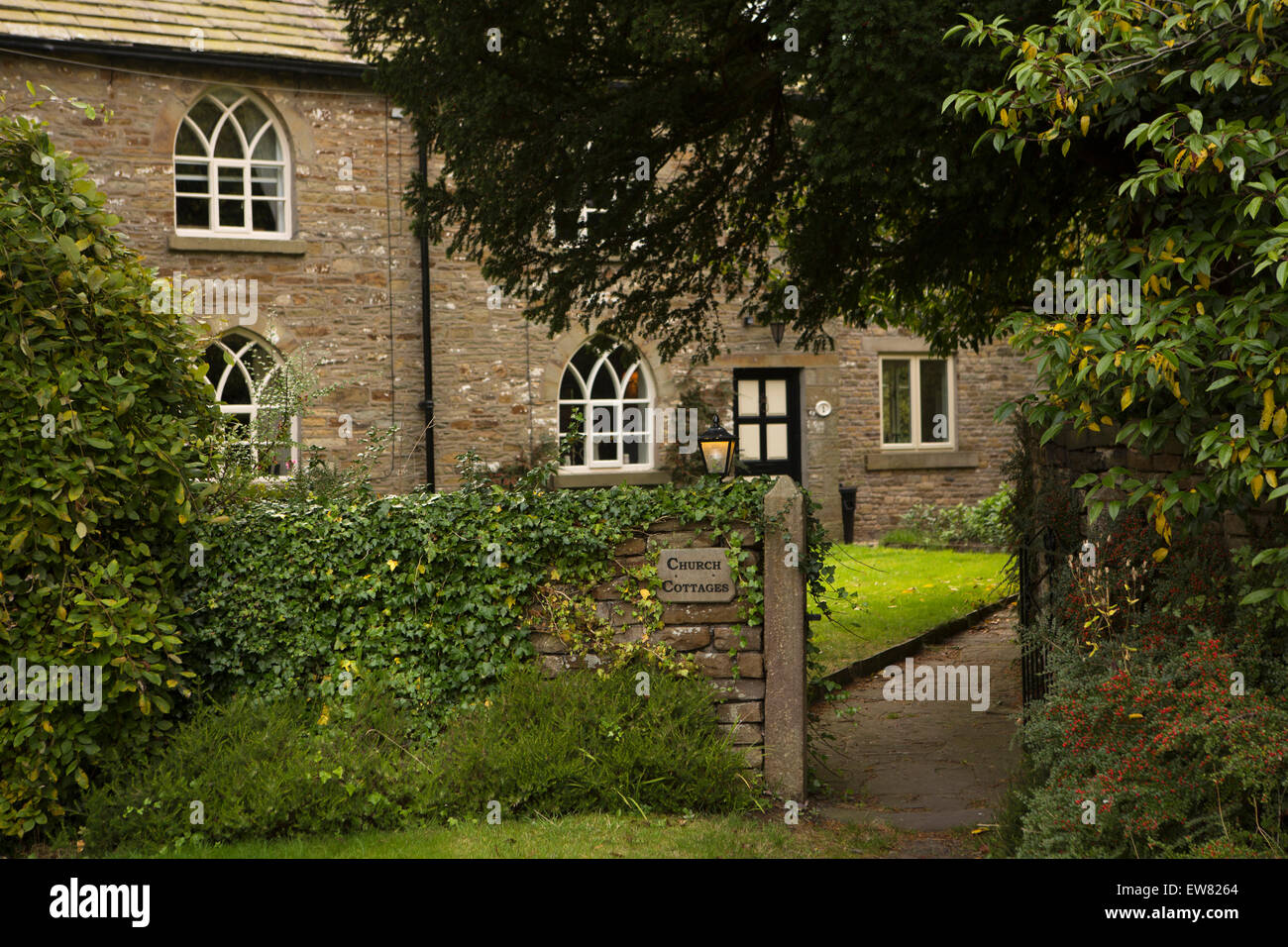 UK, England, Cheshire, Pott Shrigley, church cottages with gothic arched windows next to churchyard Stock Photo