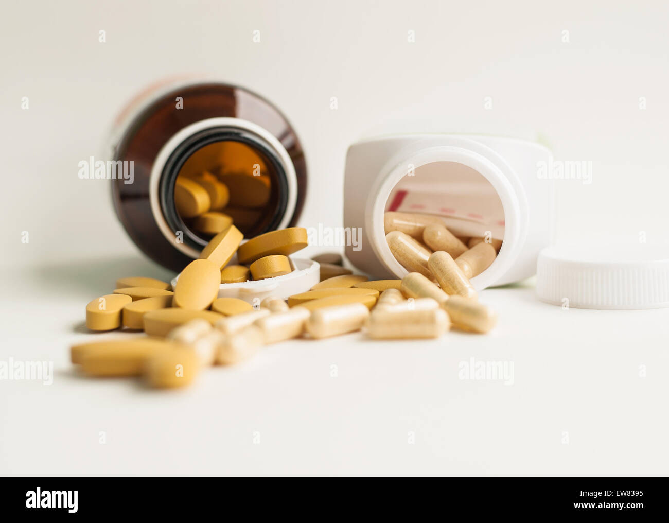 Vitamin and herb capsule spilling out of a bottle Stock Photo