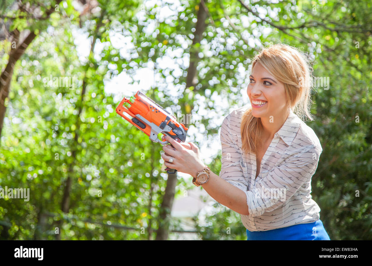 Young woman playing with nerf guns in park in Florida Stock Photo