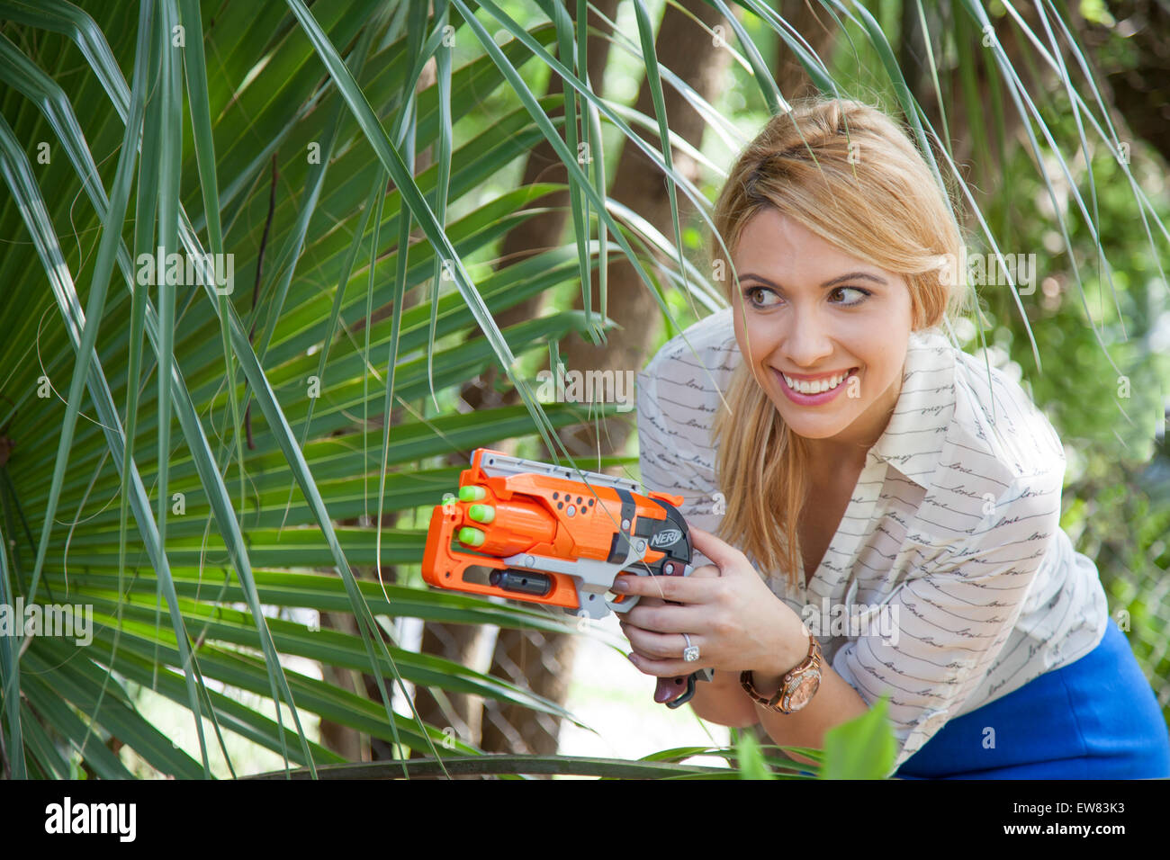 Young woman playing with nerf guns in park in Florida Stock Photo