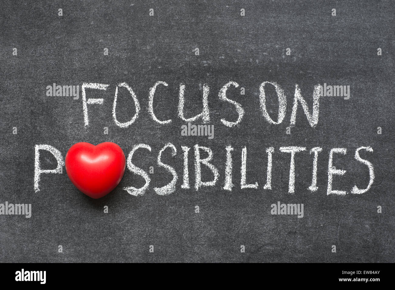 focus on possibilities phrase handwritten on blackboard with heart symbol instead of O Stock Photo