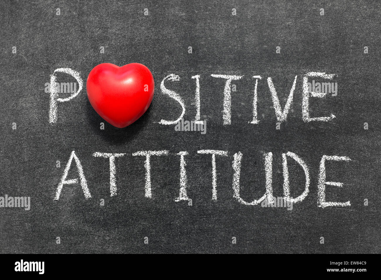 positive attitude phrase handwritten on blackboard with heart symbol instead of O Stock Photo