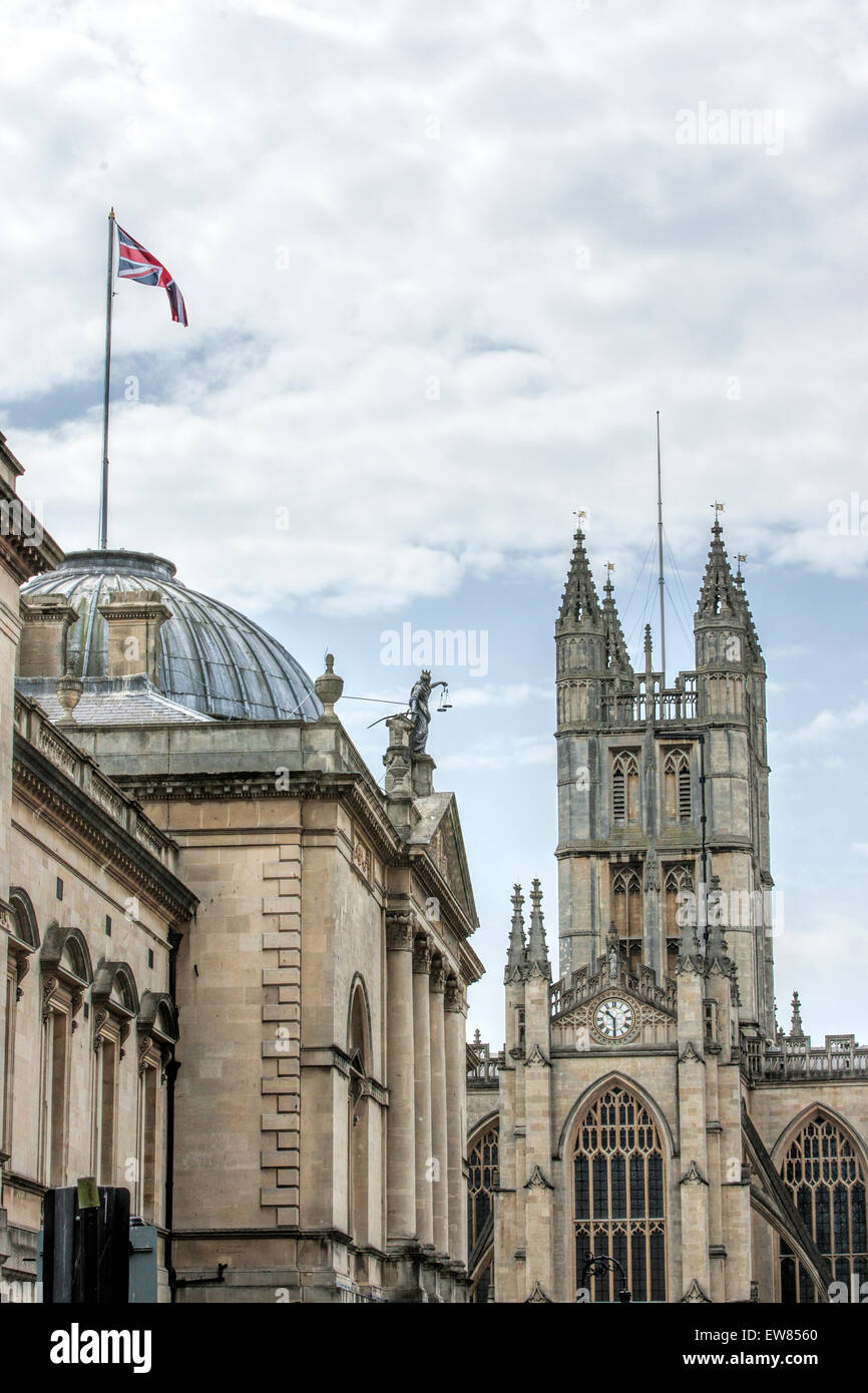 Union flag flying high on a building next to the North Transept and clock of Bath Abbey in the city of Bath in Somerset Stock Photo