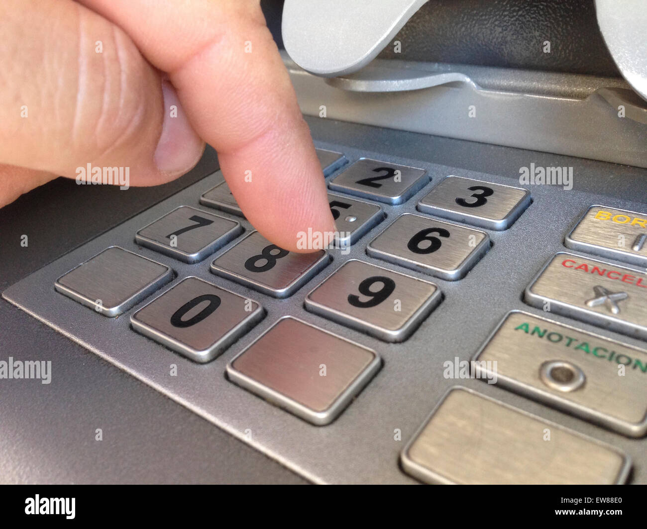 Man finger pressing password number on ATM machine Stock Photo