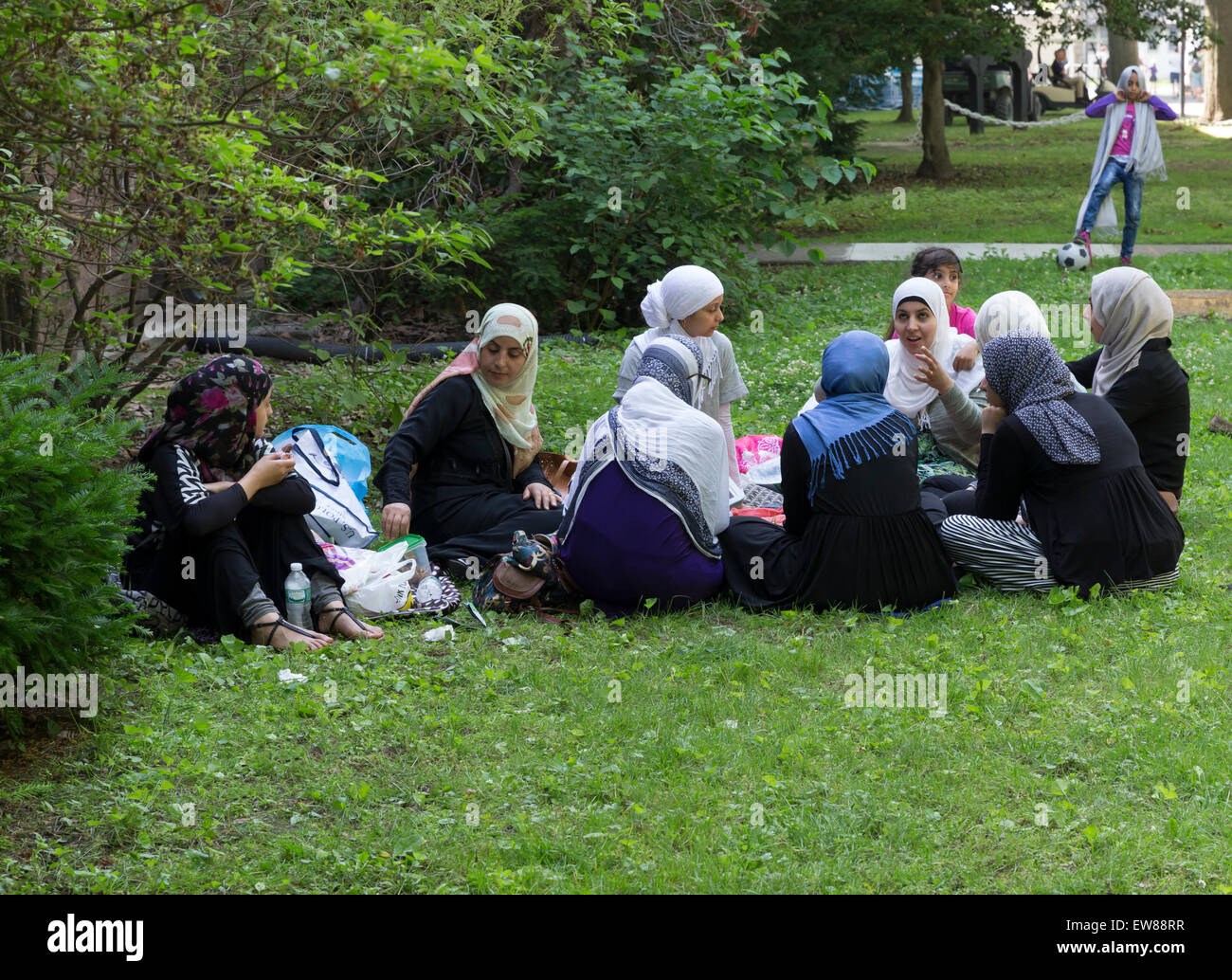 New York, NY - June 15, 2015: Young Muslim women enjoy picnic on Governors Island Stock Photo