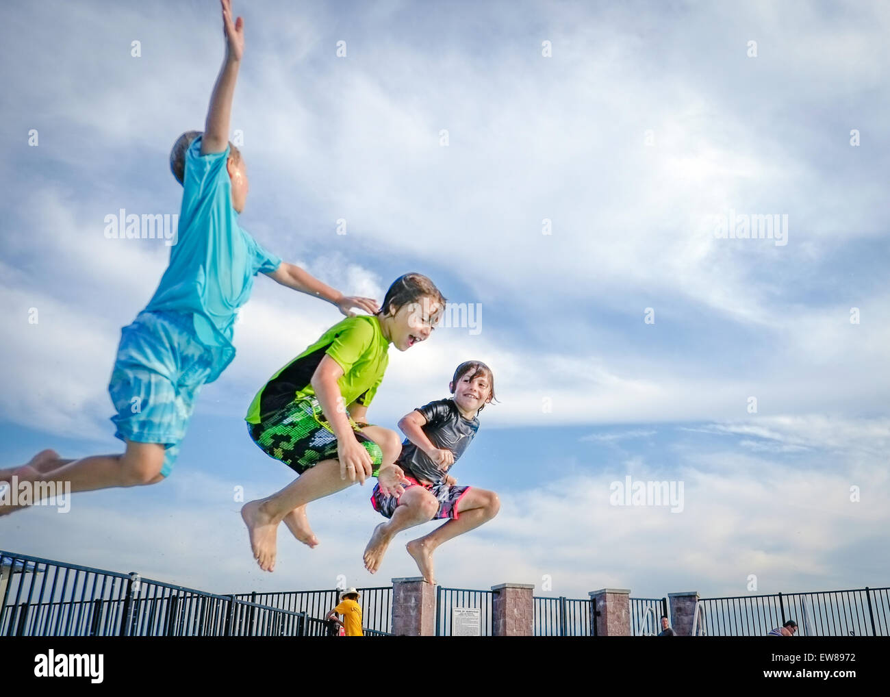 Three kids jumping into the pool at Hewlett Point Park .East Rockaway