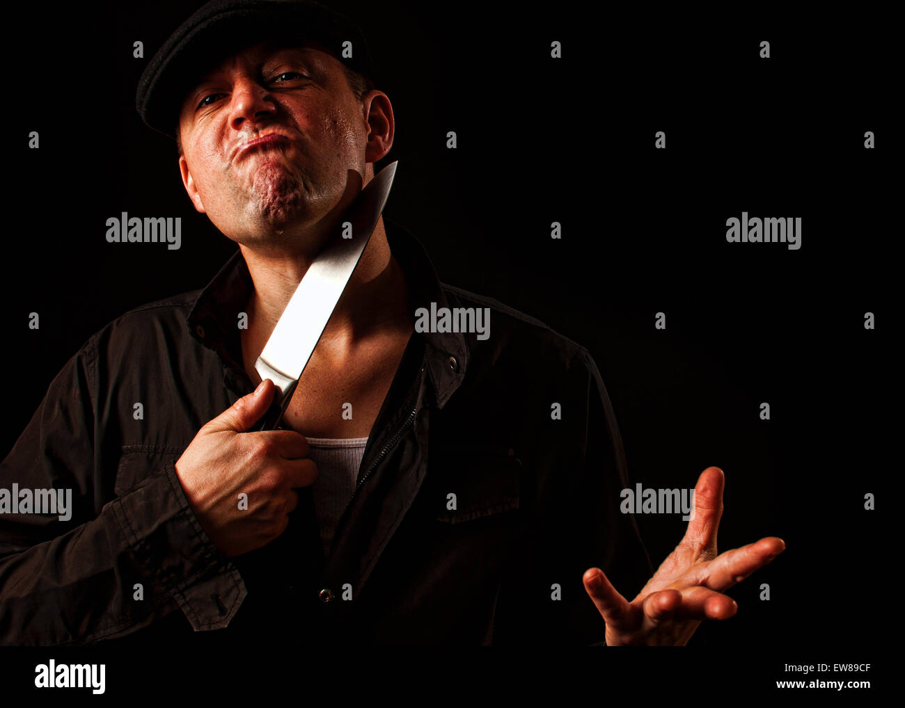 a crazed angry criminal holding a knife to his throat Stock Photo Alamy