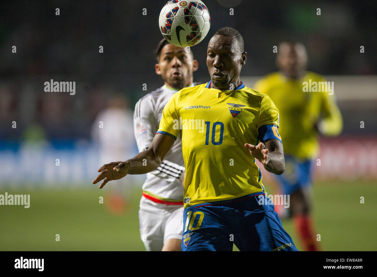 Rancagua, Chile. 19th June, 2015. Mexico's Javier Aquino (back) vies with Ecuador's Walter Ayovi (front) during the Group A match of the Copa America Chile 2015, held in the El Teniente stadium, in Rancagua, Chile, on June 19, 2015. Ecuador won 2-1. Credit:  Luis Echeverria/Xinhua/Alamy Live News Stock Photo