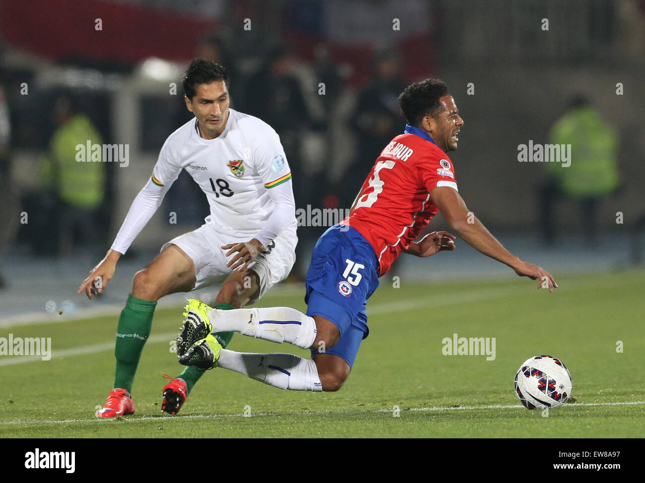 Santiago, Chile. 19th June, 2015. Chile's Jean Beausejour (R) vies with Bolivia's Ricardo Pedriel during the Group A match of the Copa America Chile 2015, held in the National Stadium, in Santiago, Chile, on June 19, 2015. Credit:  Jorge Villegas/Xinhua/Alamy Live News Stock Photo
