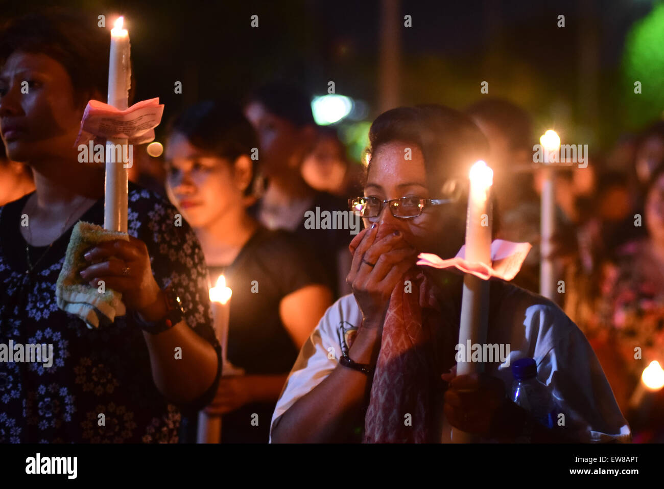 Women pilgrims bring lit candles as they are marching during a procession to commemorate Good Friday in Larantuka, East Nusa Tenggara, Indonesia. Stock Photo