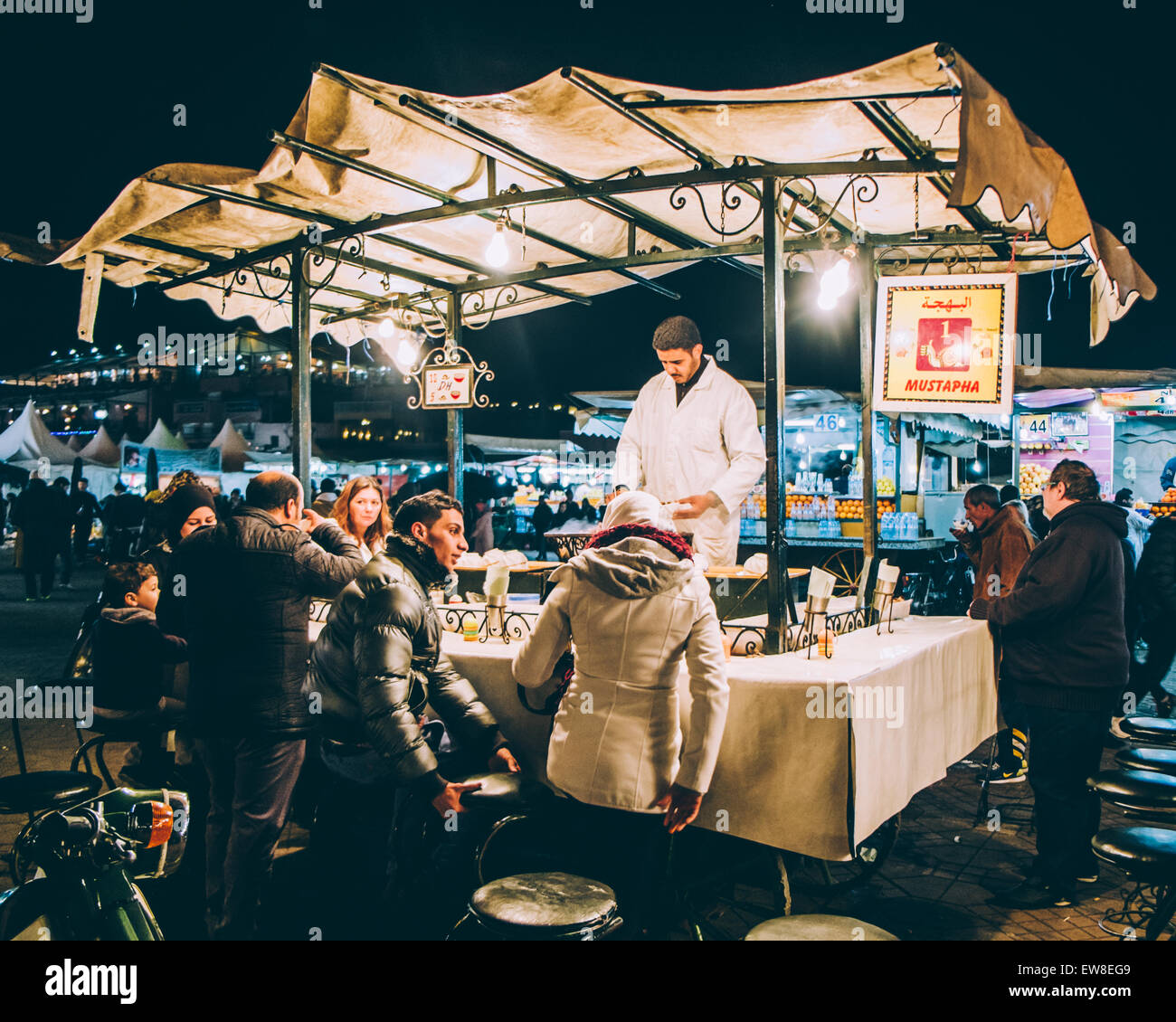 A food seller in Marrakech medina serves customers at night Stock Photo