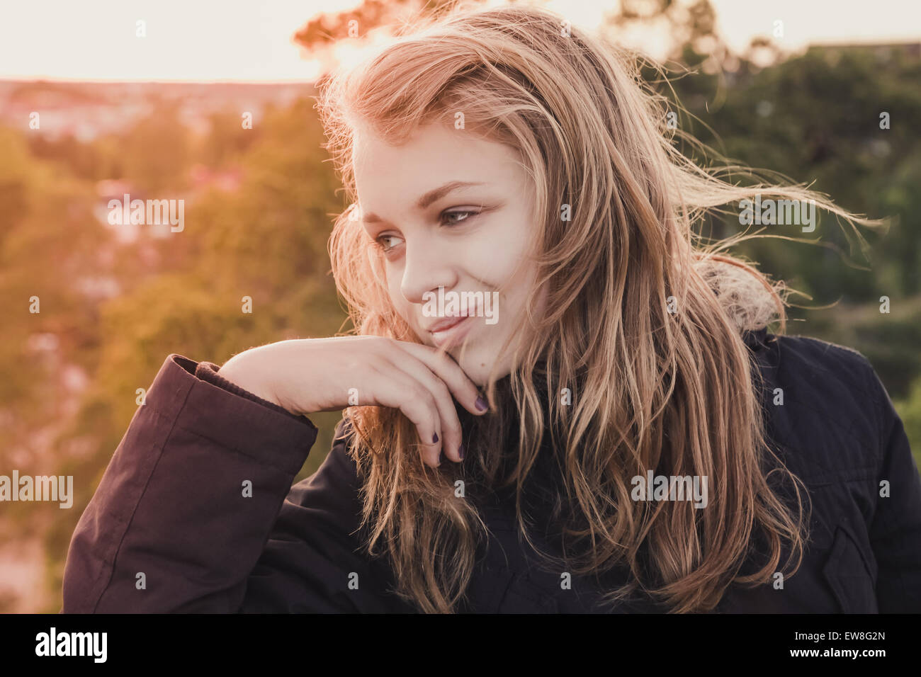 Outdoor closeup portrait of smiling teenage Caucasian blond girl with ...
