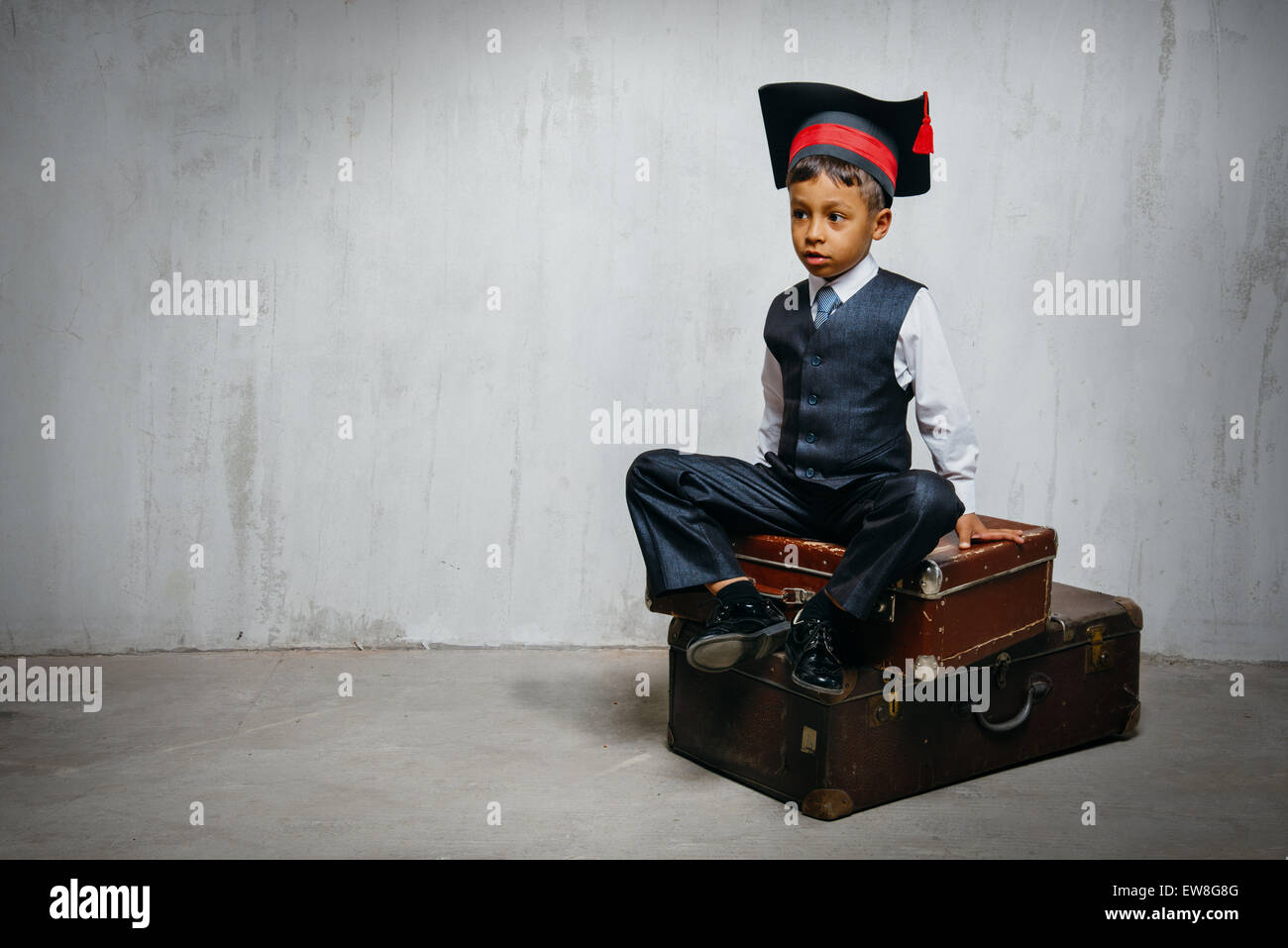 small black boy in graduation hat sits 