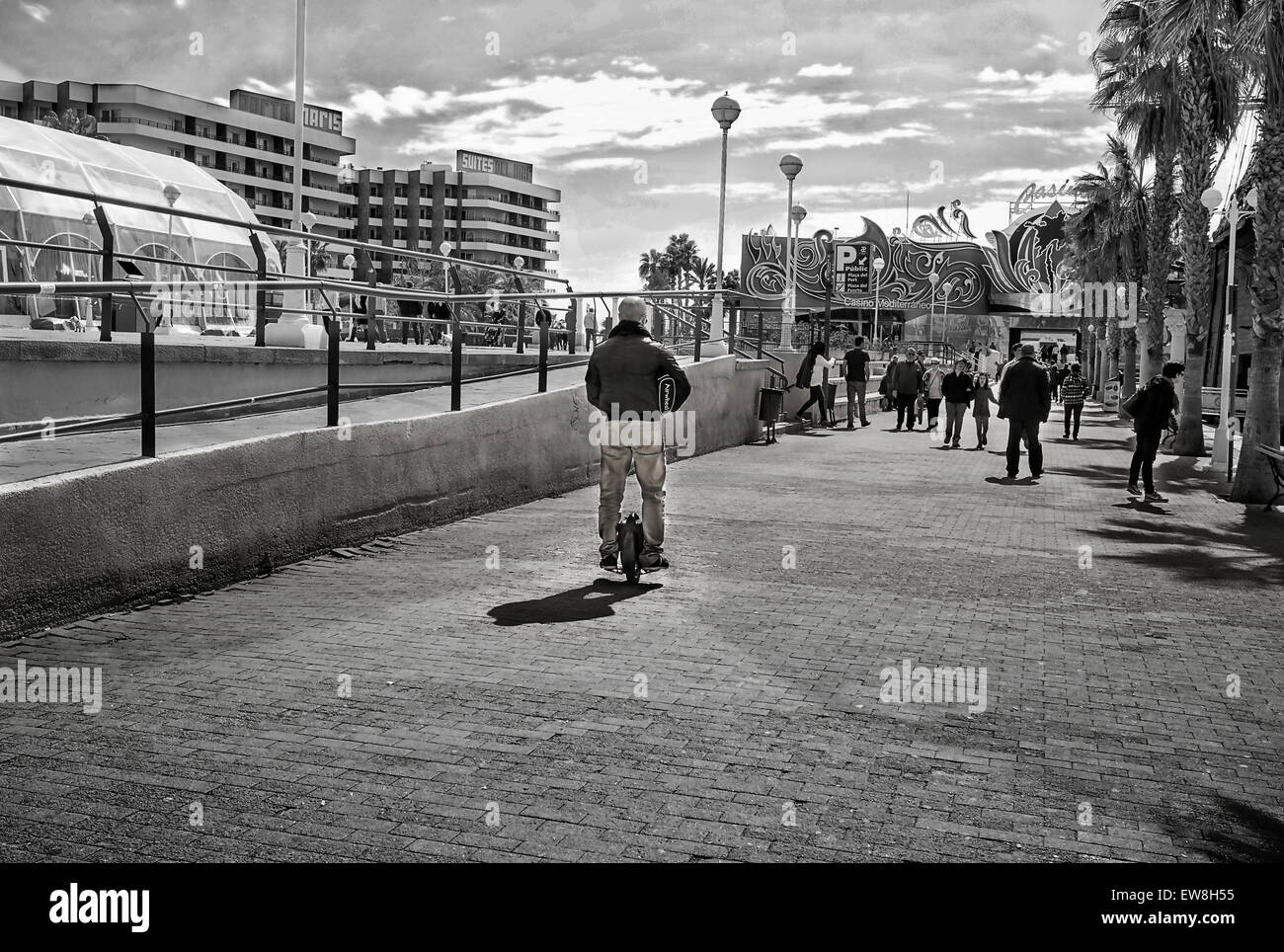 -Man running with electric wheal- Alicante's Port (Spain). Stock Photo