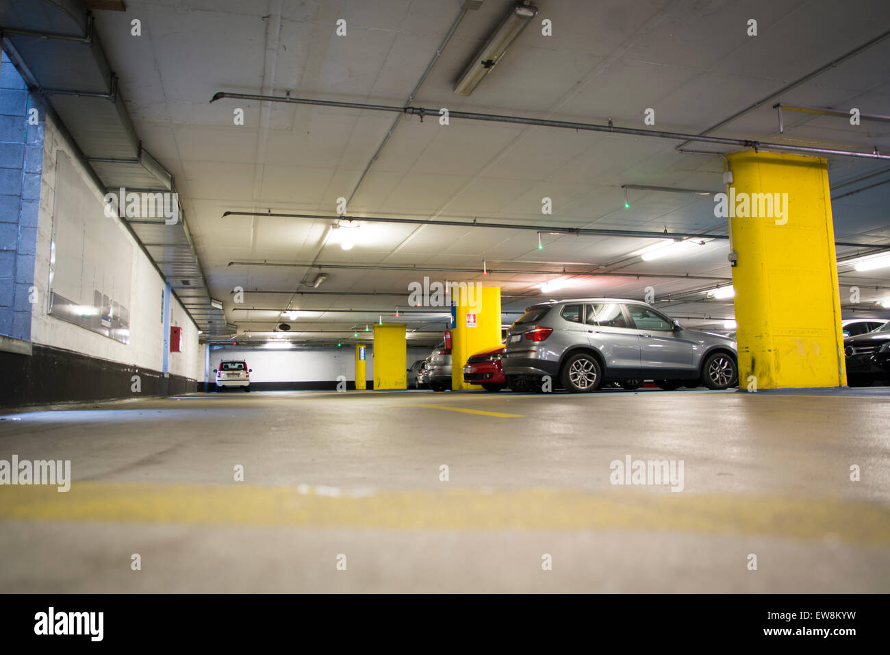 Half empty underground garage or parking lot, with a few cars Stock Photo