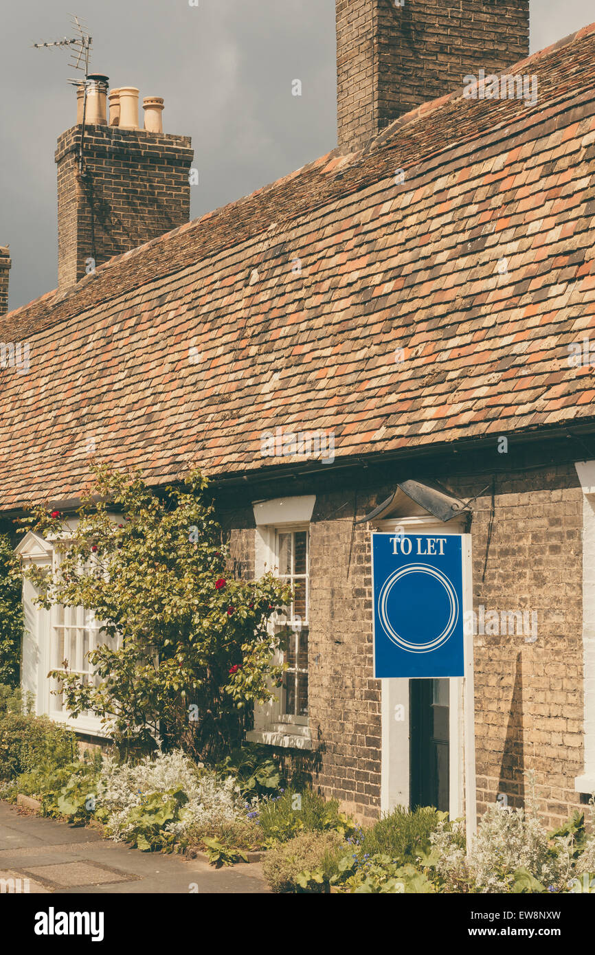 'To Let' sign infront of a cottage vertical image Stock Photo - Alamy