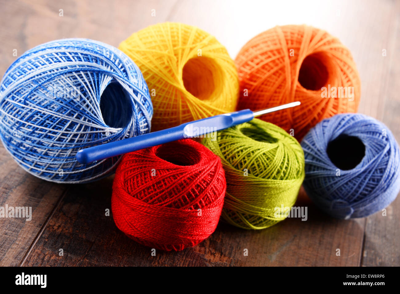 Colorful yarn for crocheting and hook on wooden table Stock Photo Alamy
