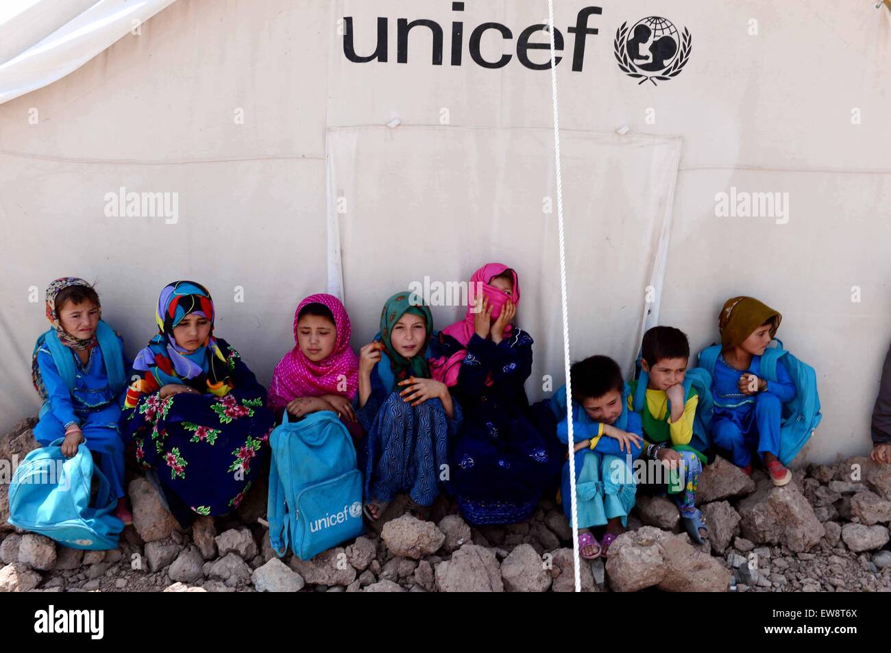 Herat, Afghanistan. 20th June, 2015. Afghan refugee children sit outside a tent at a refugee camp in Herat Province, western Afghanistan, on June 20, 2015. An unprecedented number of people have to flee their homes because of wars, conflict and persecution, with worldwide forced displacement numbers reaching 59.5 million by the end of 2014, according to a report issued on Thursday by the UN office for High Commissioner for Refugees (UNHCR). © Sardar/Xinhua/Alamy Live News Stock Photo