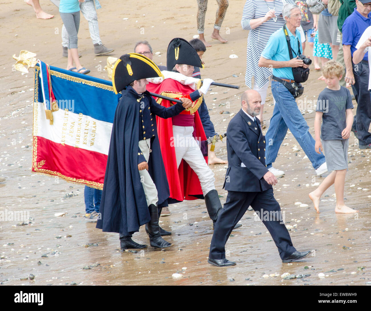 Broadstairs, Kent. 20th June, 2015. In commemoration of events after the Battle of Waterloo, a despatch is being carried from Belgium to London between 18 and 21 June. This morning, the despatch arrived at Broadstairs, Kent, carried by characters representing Major Henry Percy and Commander James White RN who brought the original despatch in 1815. The captured French Eagles are carried across te beach. Credit:  Paul Martin/Alamy Live News Stock Photo