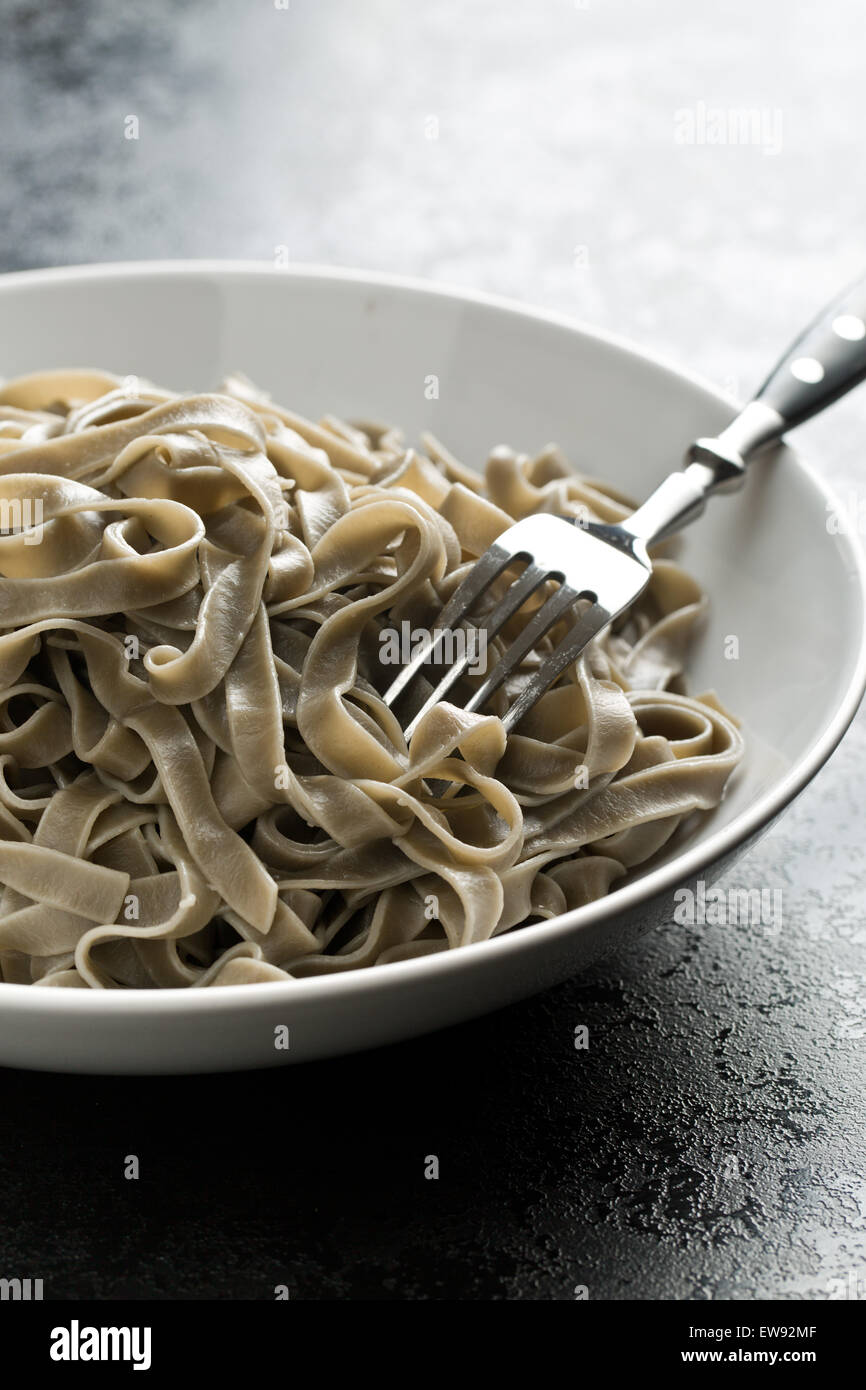 cooked black tagliatelle pasta on plate Stock Photo Alamy